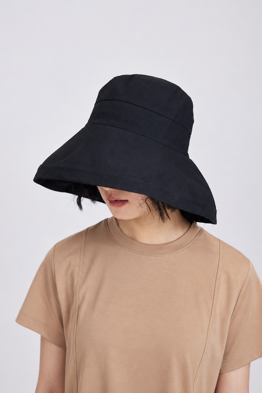 Margo & Main – Elke black wide-brim sun hat worn with the brim tilted low over the eyes, front view