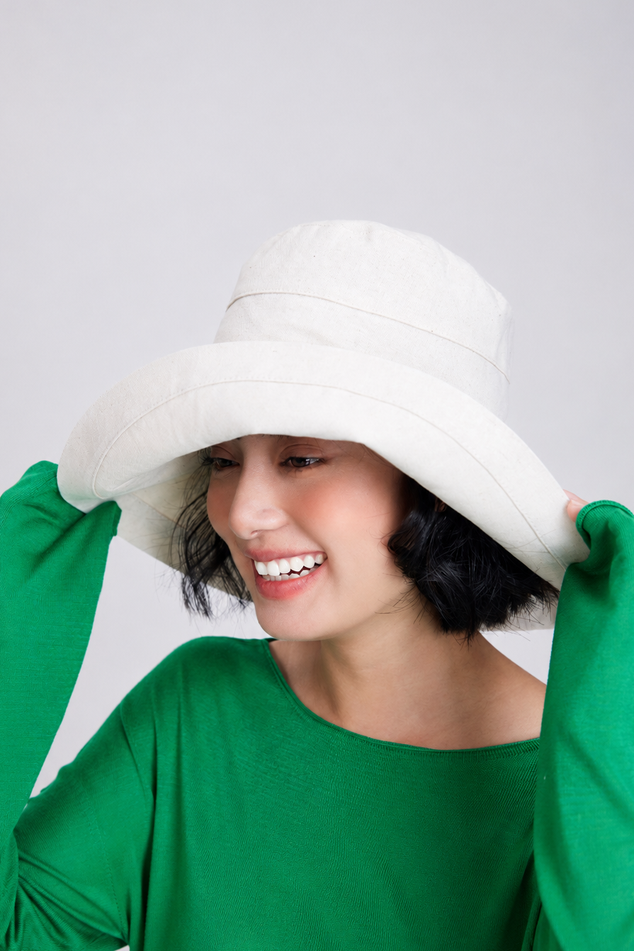 Margo & Main – Elke hemp beige wide-brim bucket sun hat held at the brim, front view, handmade linen-cotton UPF 50+ hat