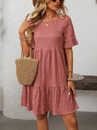 Margo & Main – Vianne dusty rose textured tiered short-sleeve dress, front view with a straw tote on the forearm, US women's sizes