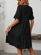 Margo & Main – Vianne black textured tiered short-sleeve dress, front view of the tiered hem with hands at the sides, US women's sizes