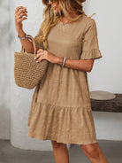 Margo & Main – Vianne tan textured tiered short-sleeve dress, front view holding a straw tote at shoulder height, US women's sizes