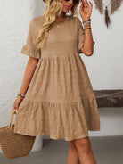 Margo & Main – Vianne tan textured tiered short-sleeve dress, front view with a straw tote on the arm, US women's sizes